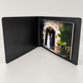 Kwik Film black clip photo flip book, shown open with example prints; choose print size and pack quantity on the product page.
