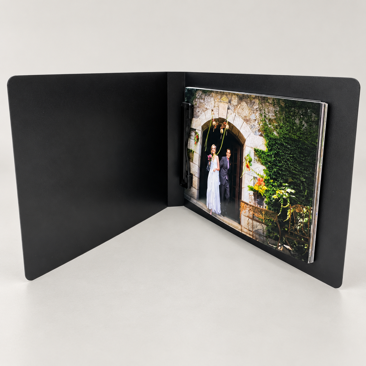 Kwik Film black clip photo flip book, shown open with example prints; choose print size and pack quantity on the product page.