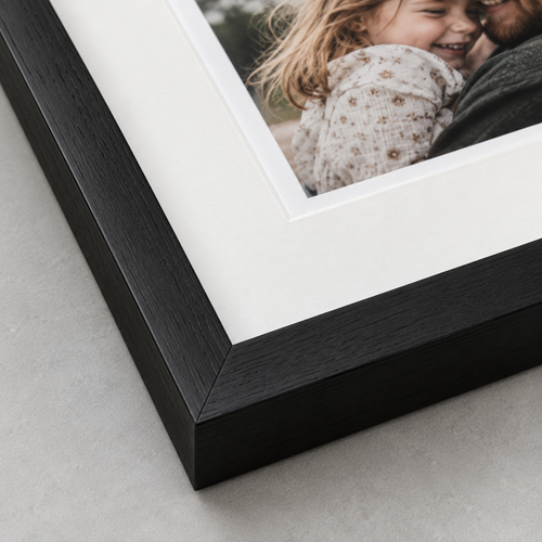 Illustrative close-up of a mounted photograph and wooden frame. The number of photographs and layout depend on the selected product.